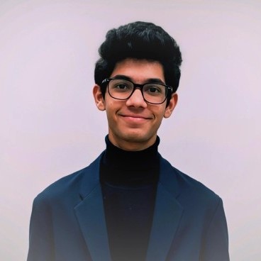 Neev Jain wearing glasses and a dark blazer